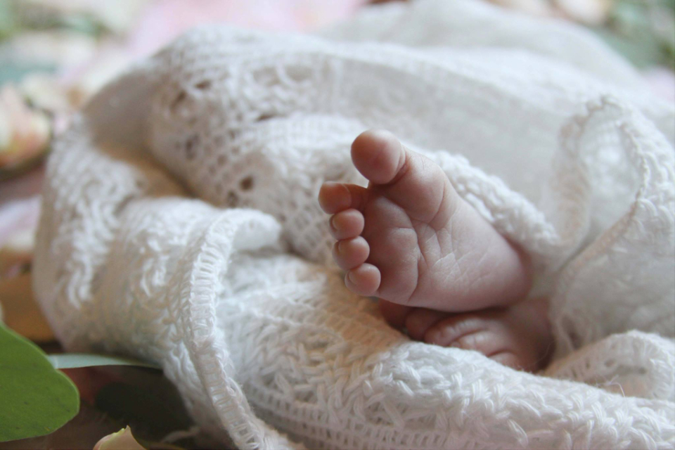 Pieds de nouveau-né dans une couverture tricotée