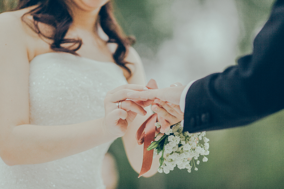 Mains de mariés avec alliances et bouquet